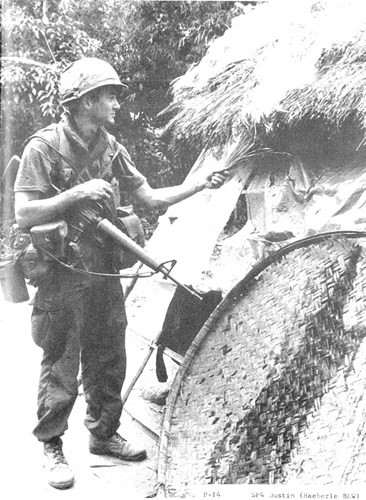 American soldier setting fire to a Vietnamese home